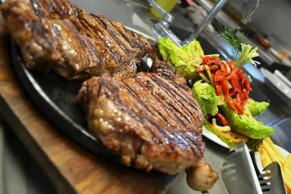 Corte de carne ahumado y sellado en una plancha con vegetales