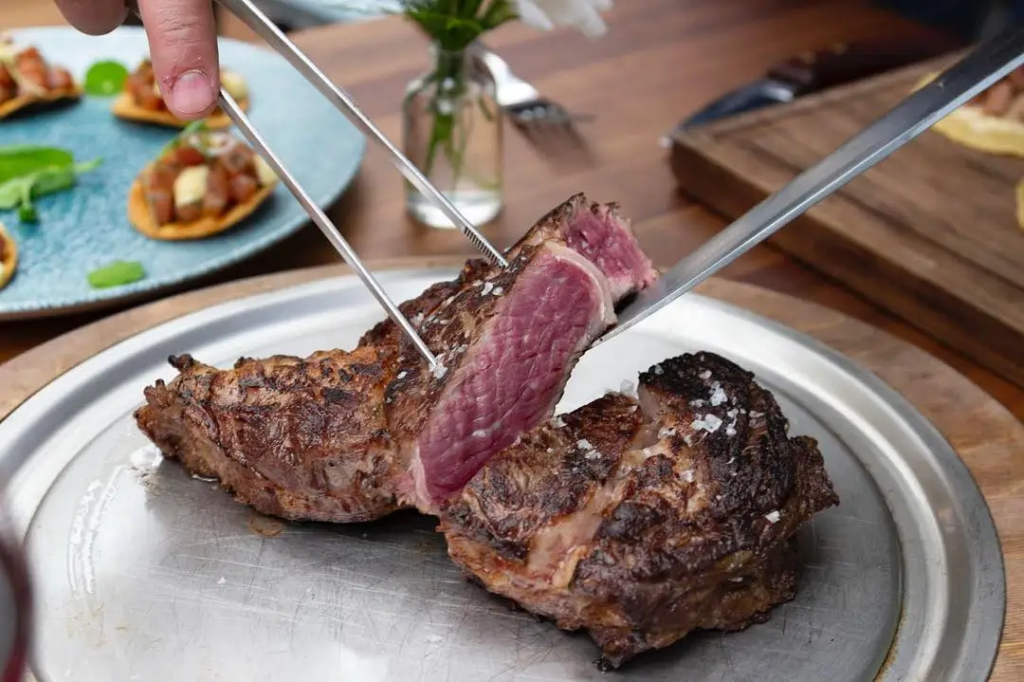 Corte de carne termino medio en un charola de metal