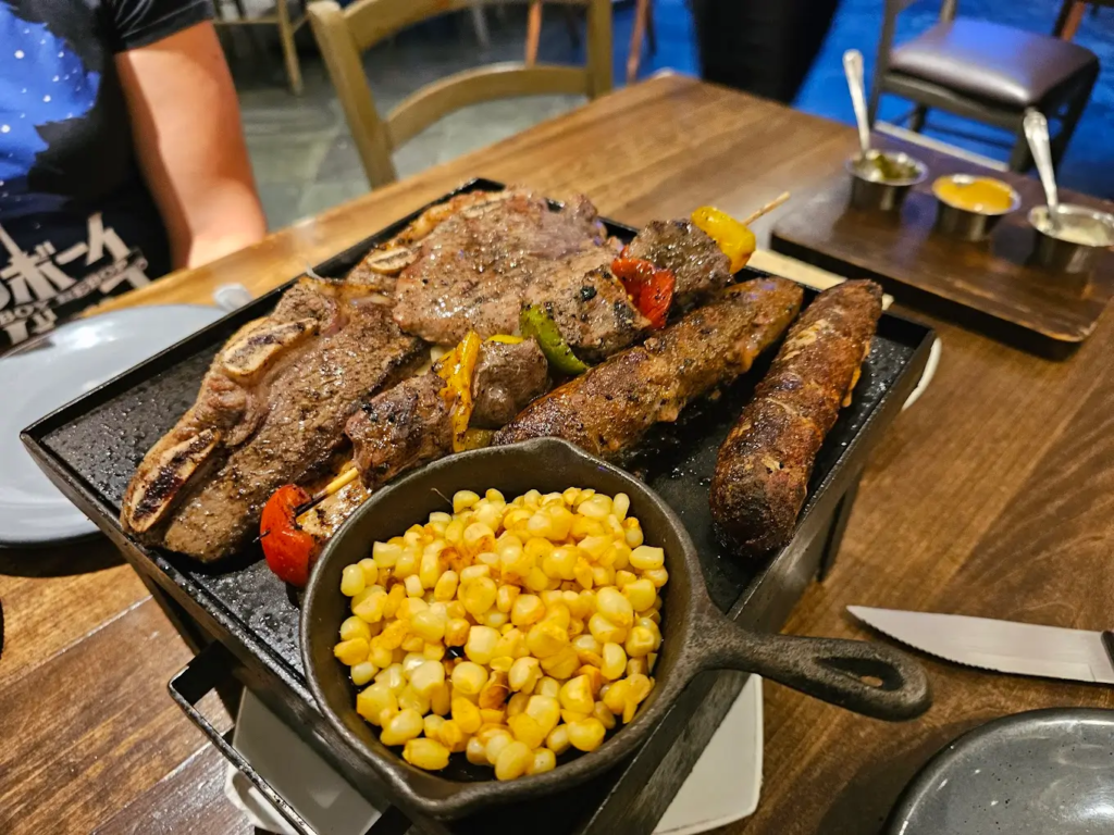 Platillo de carne al asador acompañado de trozos de elote amarillo