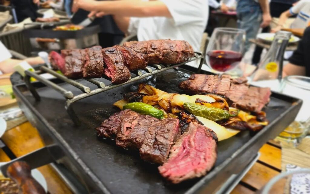 Carne asada a la parrilla con trozos de piña y una copa de vino