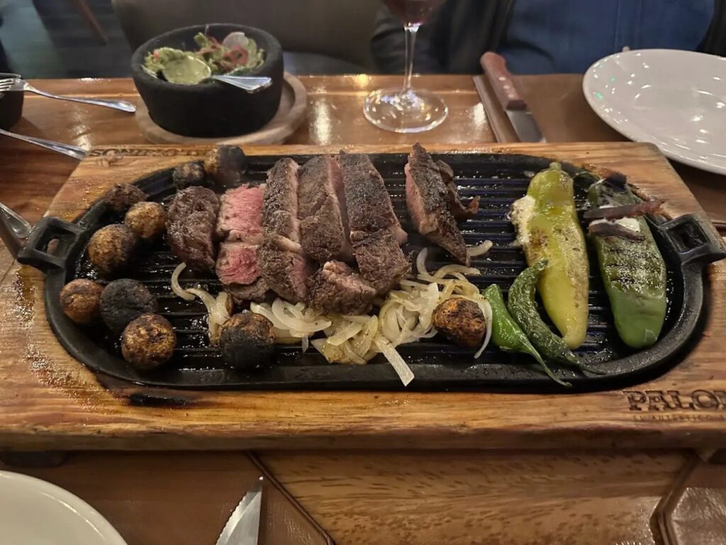 Platillo de carne asada, acompañada de cebollitas y chiles toreados