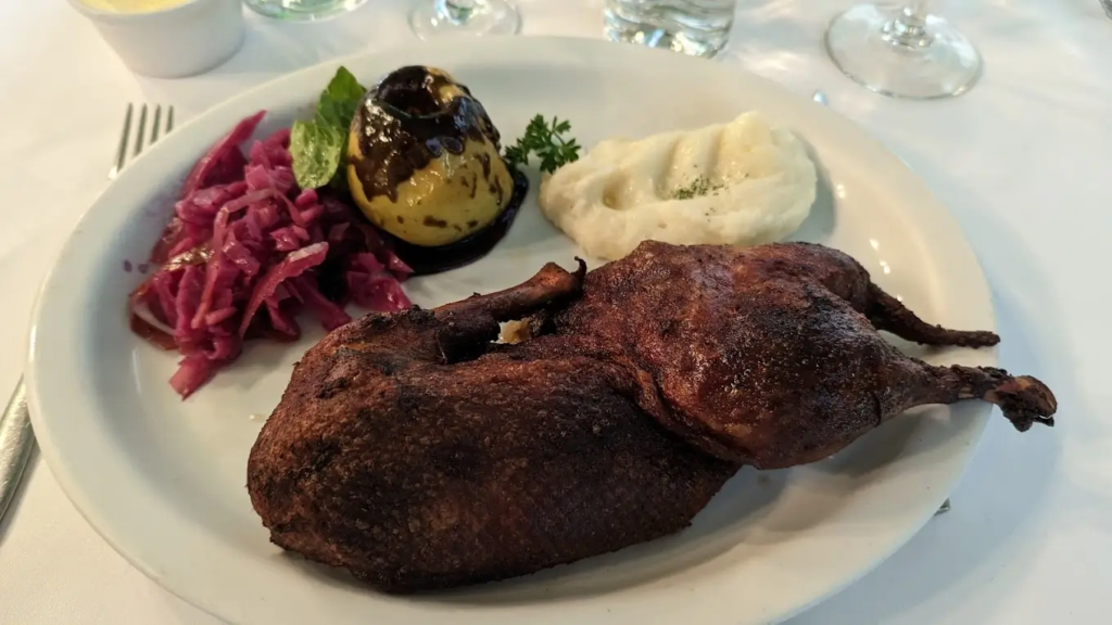 Platillo de pato acompañado de pasta y ensalada