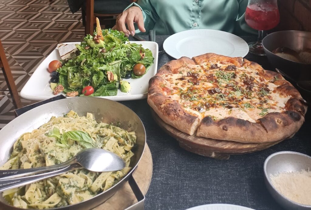 Variedad de platillos como pizza, ensalada y pasta, tradicional de la cocina italiana