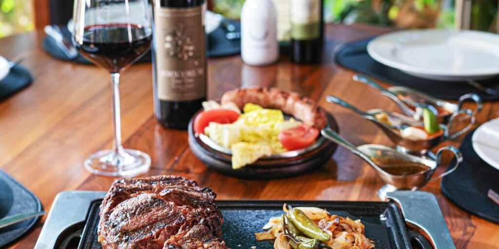 Platillos de comida argentina acompañada de copas de vino