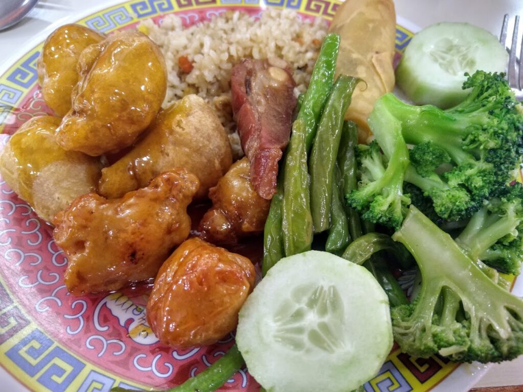 comida china como trozos de cerdo en salsa, arroz y verduras